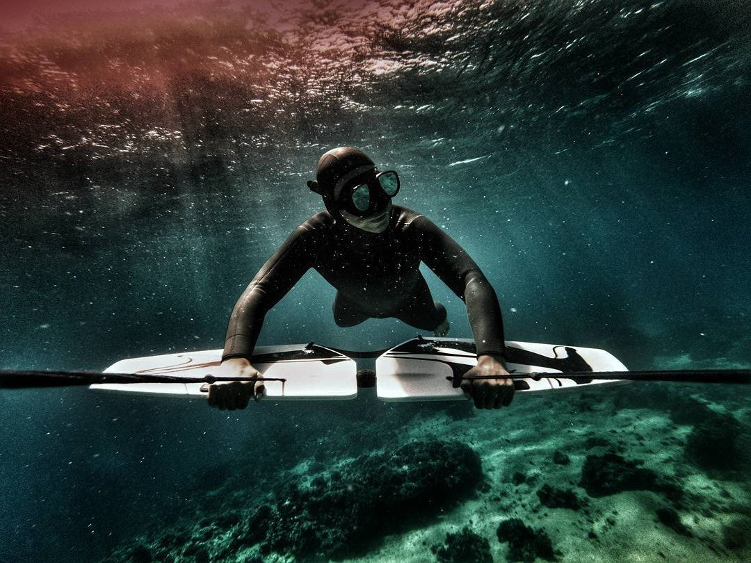 freediver in wetsuit with subwing