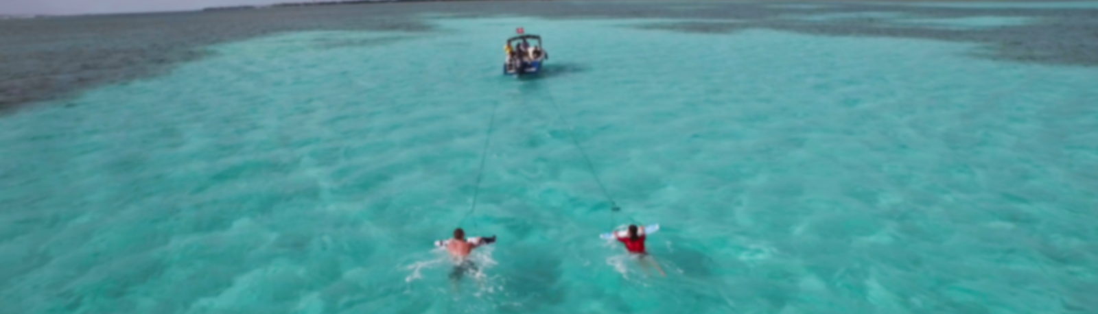 Drone shot of boat pulling twp subwingers blurry background