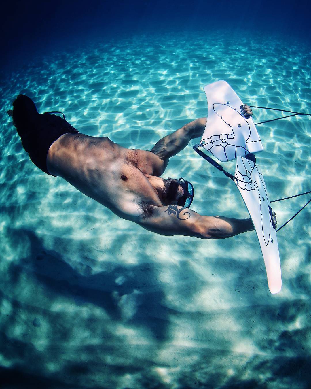 subwing roll trick over white sand bottom