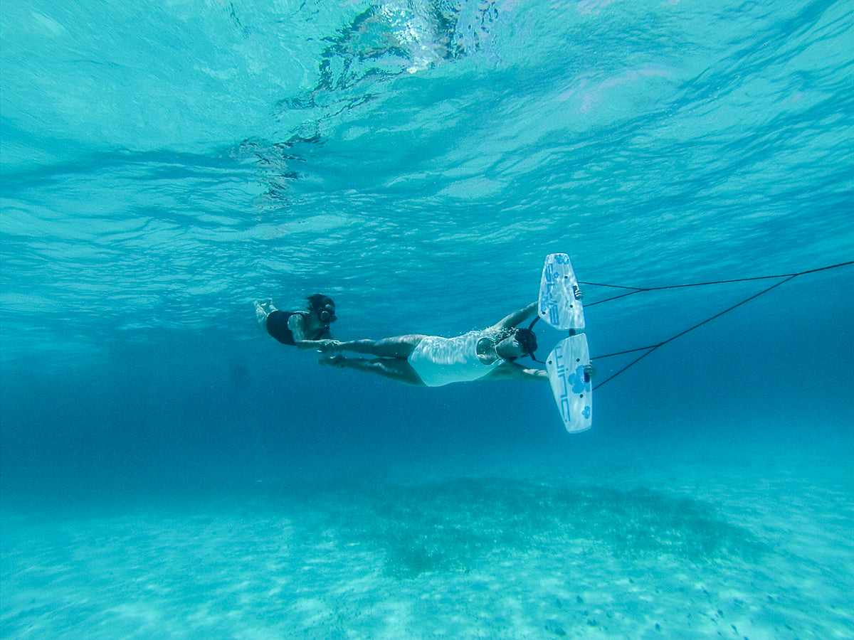 two girls tandem subwing in crystal clear water