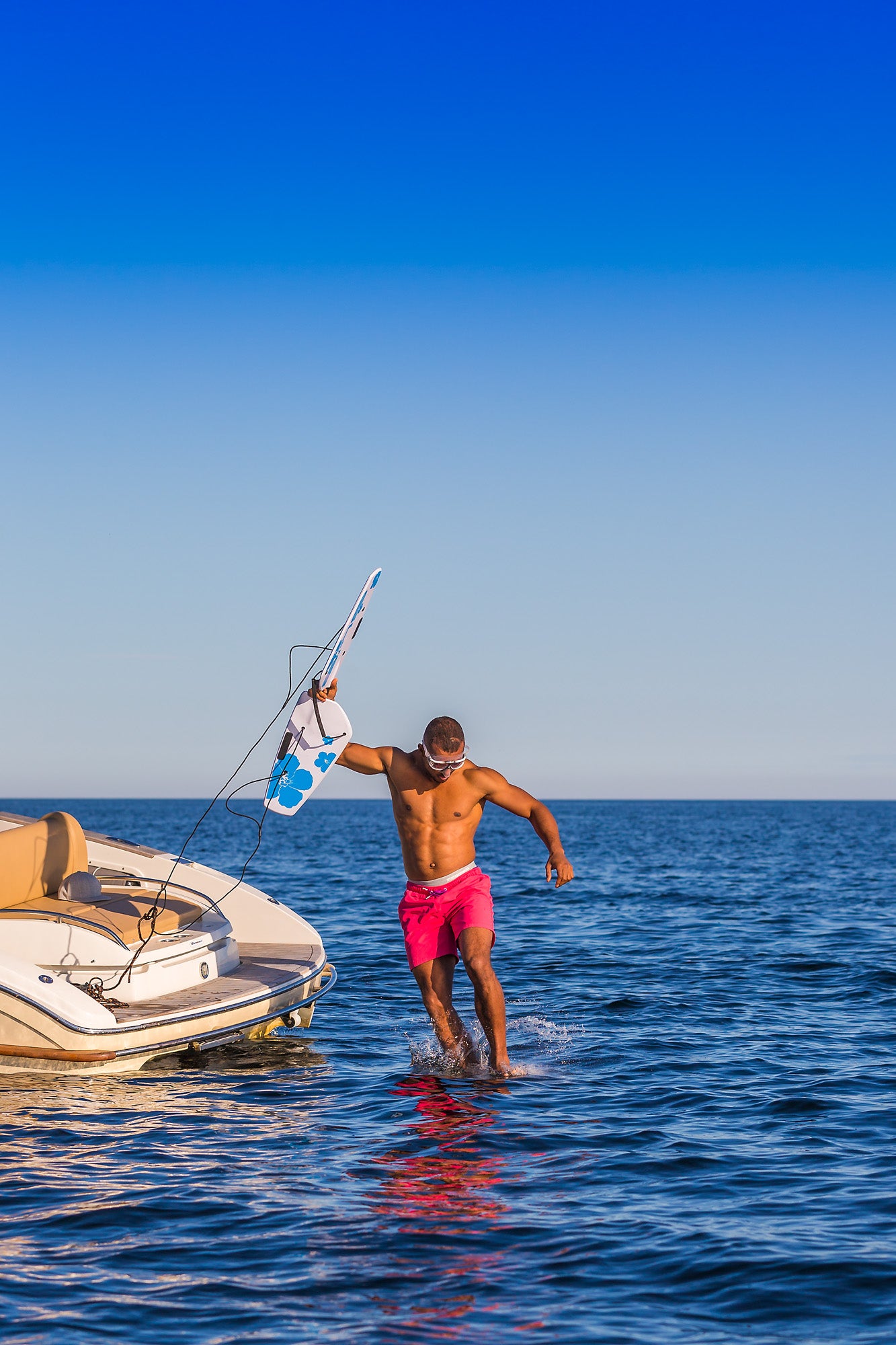 Jumping from boat in water with subwing in hand