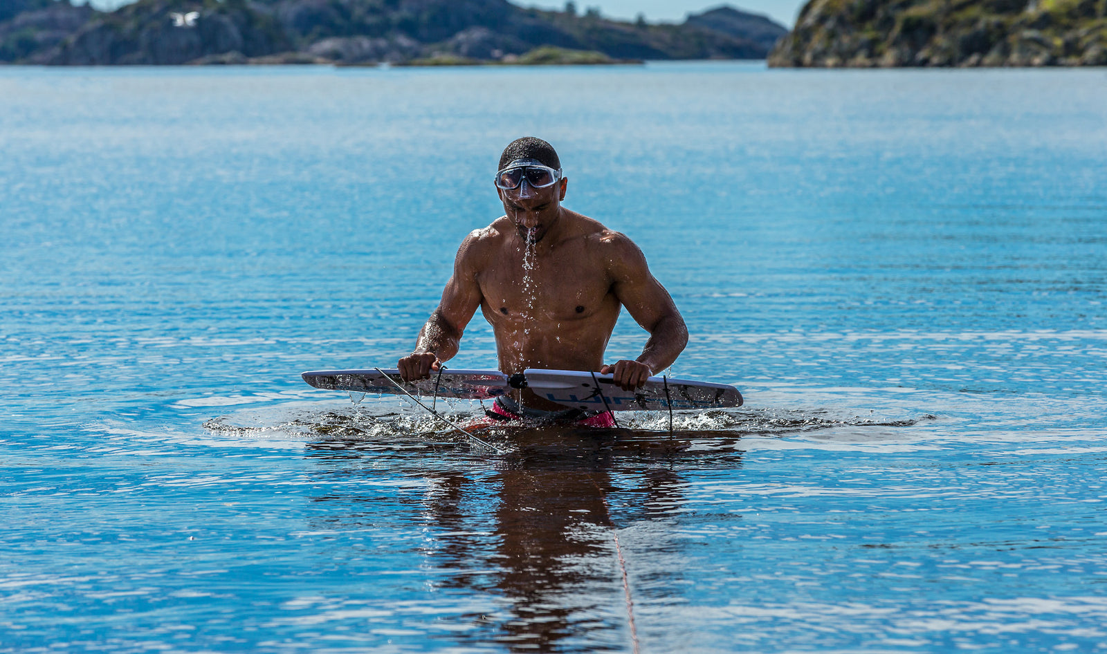 ripped guy comin up from water with subwing