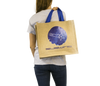 Woman holding jute beach bag with Subwing logo